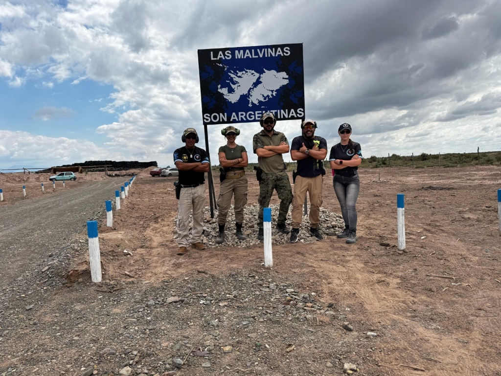 Integrantes e Instructores del Polígono frente al cartel Las Malvinas son Argentinas
